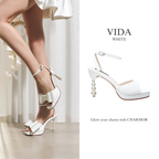 Model wearing The Vida pearl platform heels in white